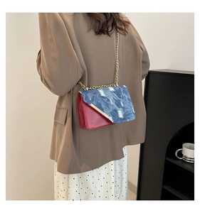 Dettaglio borsa a tracolla color-block con trama in denim consumato e catena dorata