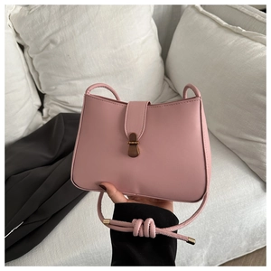 Detailed shot of pink leather shoulder bag with vintage bronze clasp and knotted strap