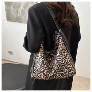 Detail of leopard print tote bag with black bow drawstring and slender shoulder straps
