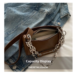 Detail view of the brown leather pillow bag showing internal capacity and metal chain