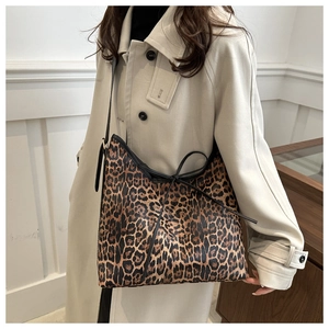 Dettaglio borsa hobo leopardata con finiture nere sulla spalla del trench coat