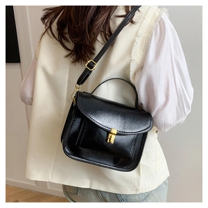Vue arrière du sac à bandoulière noir chic avec fermoir doré et sangle réglable