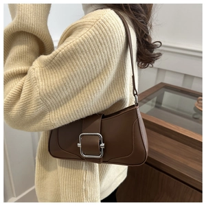 Detailed side view of brown vintage leather shoulder bag with metallic buckle closure