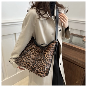 Borsa hobo leopardata con fiocco nero indossata con un trench beige elegante