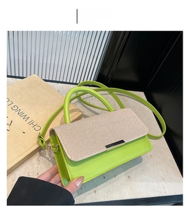 Détail du rabat en cuir vert et tissage beige sur un sac à bandoulière pour femme