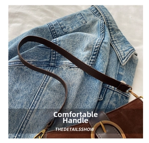 Close-up of brown suede bag featuring a gold round buckle and leather shoulder strap