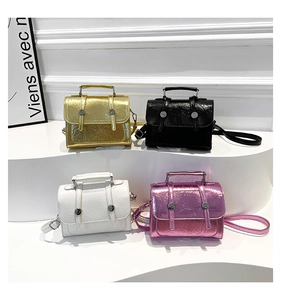 Macro detail of glossy metallic mini crossbody bags with textured pleats and top handle
