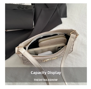 Dettaglio della grande capacità interna della borsa a tracolla beige con monogramma
