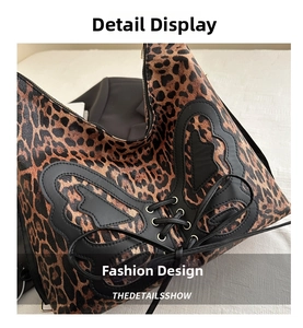 Close-up of leopard print shoulder bag featuring black butterfly leather patches and lace-up detail