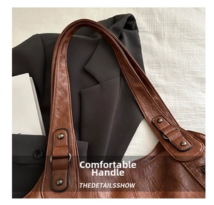 Detail of comfortable brown leather handles with reinforced stitching and metal rivets