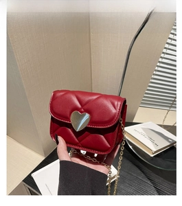 Détail du mini sac rouge matelassé avec boucle en cœur et chaîne dorée