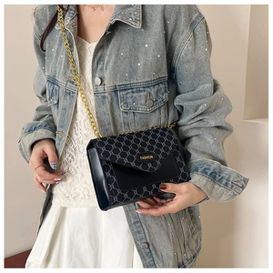 Détail du sac bandoulière vintage avec motif monogramme et plaque dorée Fashion