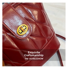 Macro view of burgundy quilted leather handbag with elegant gold metal turn-lock closure