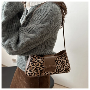 Nahaufnahme der Schultertasche mit Leopardenmuster und Lederschleife am Outfit