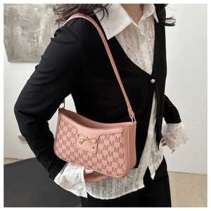 Pink shoulder bag with M-letter jacquard and golden metal bow detail on a female model