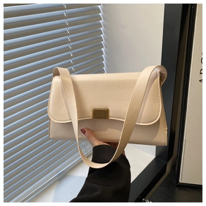 Detailed macro view of the cream leather shoulder bag with a textured gold metal buckle