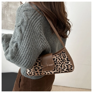 Detail der Unterarmtasche mit Leopardenmuster und Lederschleife am Outfit