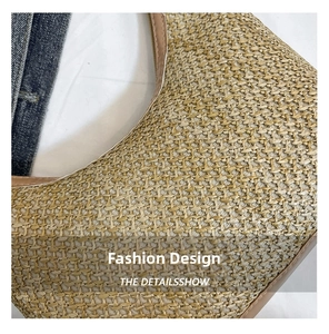 Close-up of woven paper texture and brown leather trim on a half-moon shoulder bag