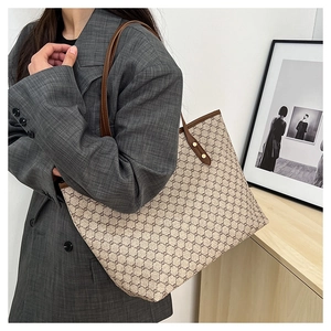 Detail view of large tote bag with geometric pattern and golden rivet accents