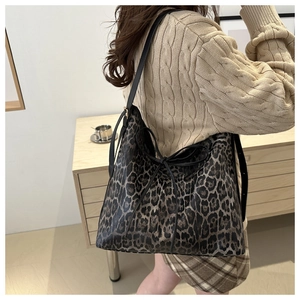 Leopard print hobo bag with bow detail shown on shoulder for daily commute look
