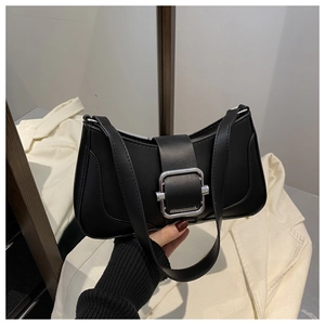 Detail of black leather underarm bag with a large silver square buckle decoration