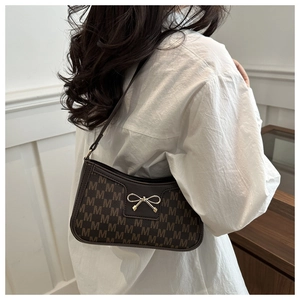 Detail of vintage brown monogram shoulder bag with elegant golden bow buckle