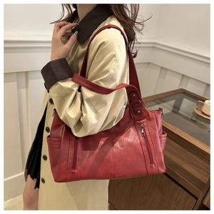 Detail of vintage burgundy tote bag with dual zippers and smooth premium leather texture