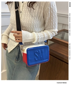Detail of tricolor crossbody bag with embossed SM letters and wide shoulder strap