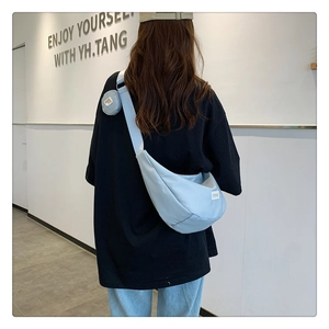 Détail du sac bandoulière croissant bleu clair avec un petit porte-monnaie rond