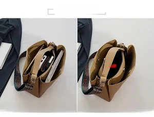 Detail of multi-compartment interior for brown leather bag with ethnic woven strap