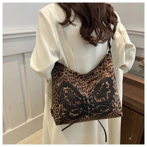 Detail of leopard print tote bag with large black bow and criss-cross ribbon straps