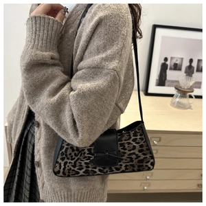 Details der Vintage-Tasche mit Leopardenmuster, schwarzem Lederbesatz und Schleife