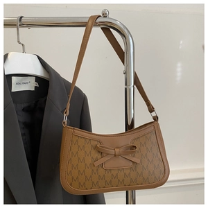 Detail of vintage brown monogram underarm bag featuring a leather bow and M-pattern print