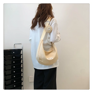 Détail du sac hobo croissant en nylon beige avec sangle réglable et mini pochette amovible
