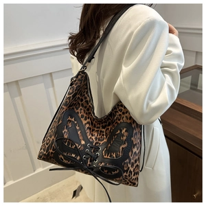 Detail of leopard print hobo bag with black leather bow and cross-strap metal eyelets