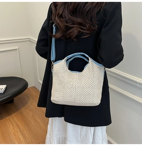 Detail of blue fabric strap and golden buckle on beige woven summer beach straw bag