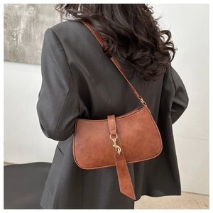 Macro shot of vintage brown shoulder bag with antique gold hook and leather texture