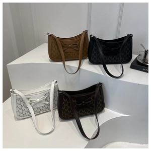 Close-up of four luxury letter print underarm bags with bow detail in various colors