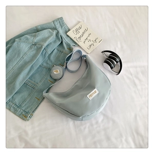 Détail du sac besace en nylon bleu clair avec bandoulière et mini porte-monnaie rond