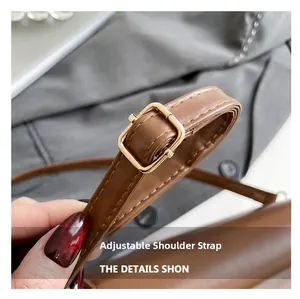 Détail de la bandoulière réglable en cuir marron avec boucle dorée sur le sac à selle