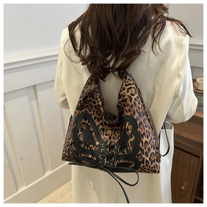 Macro shot of leopard print backpack featuring large black bow and lace-up ribbon detail