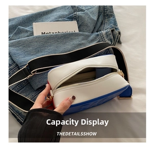 Detail showing internal capacity of the tri-color leather crossbody bag with wide strap