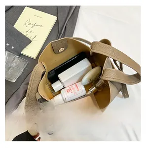 Internal capacity of the lychee texture bucket bag showing phone and cosmetics