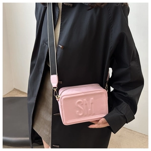 Pink crossbody bag with embossed SM letters and striped wide shoulder strap detail
