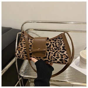 Detail der Baguette-Tasche mit Leopardenmuster und Schleife, von Model im Café gehalten