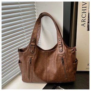 Detailed view of deep brown vintage tote bag featuring soft PU leather and side pockets