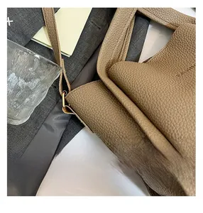 Detail of brown litchi pattern leather tote with embossed FASHION lettering