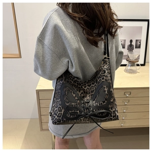 Leopard print crescent shoulder bag with black butterfly patch and lace-up design detail