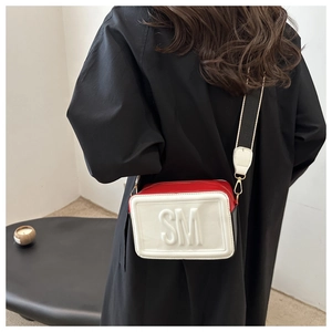 Model wearing a retro tricolor crossbody bag with wide strap and embossed SM logo