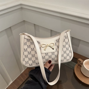 Chic beige half-moon hobo bag with M-letter monogram and golden bow detail
